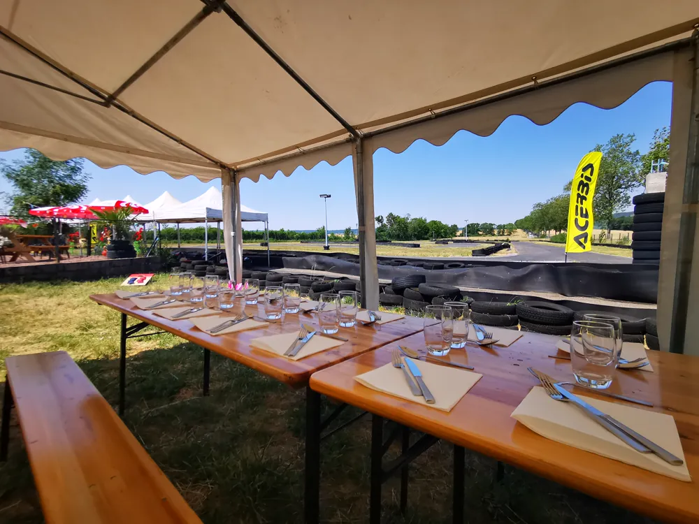 Tables dressées sous un chapiteau, face à la piste