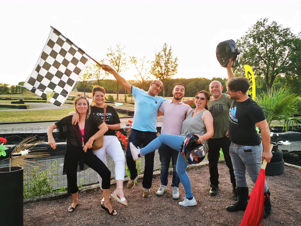 Une équipe pose avec le drapeau à damier au bord de la piste