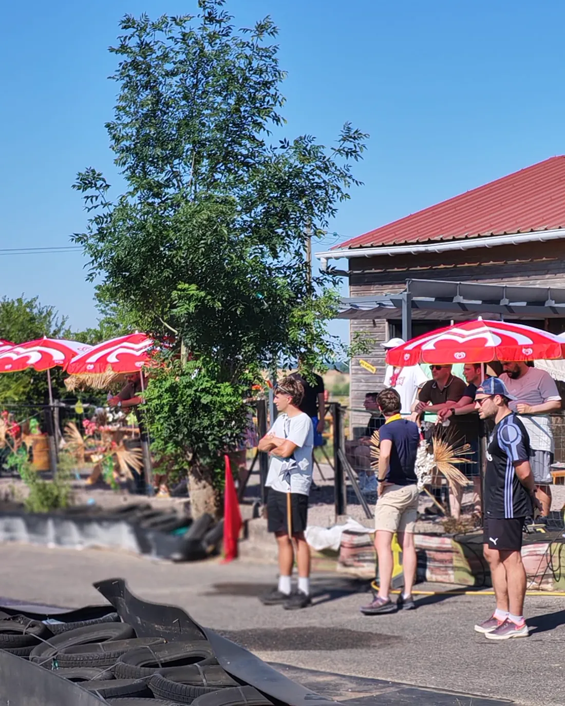 Visiteurs sur la terrasse, parasols rouges et palmier