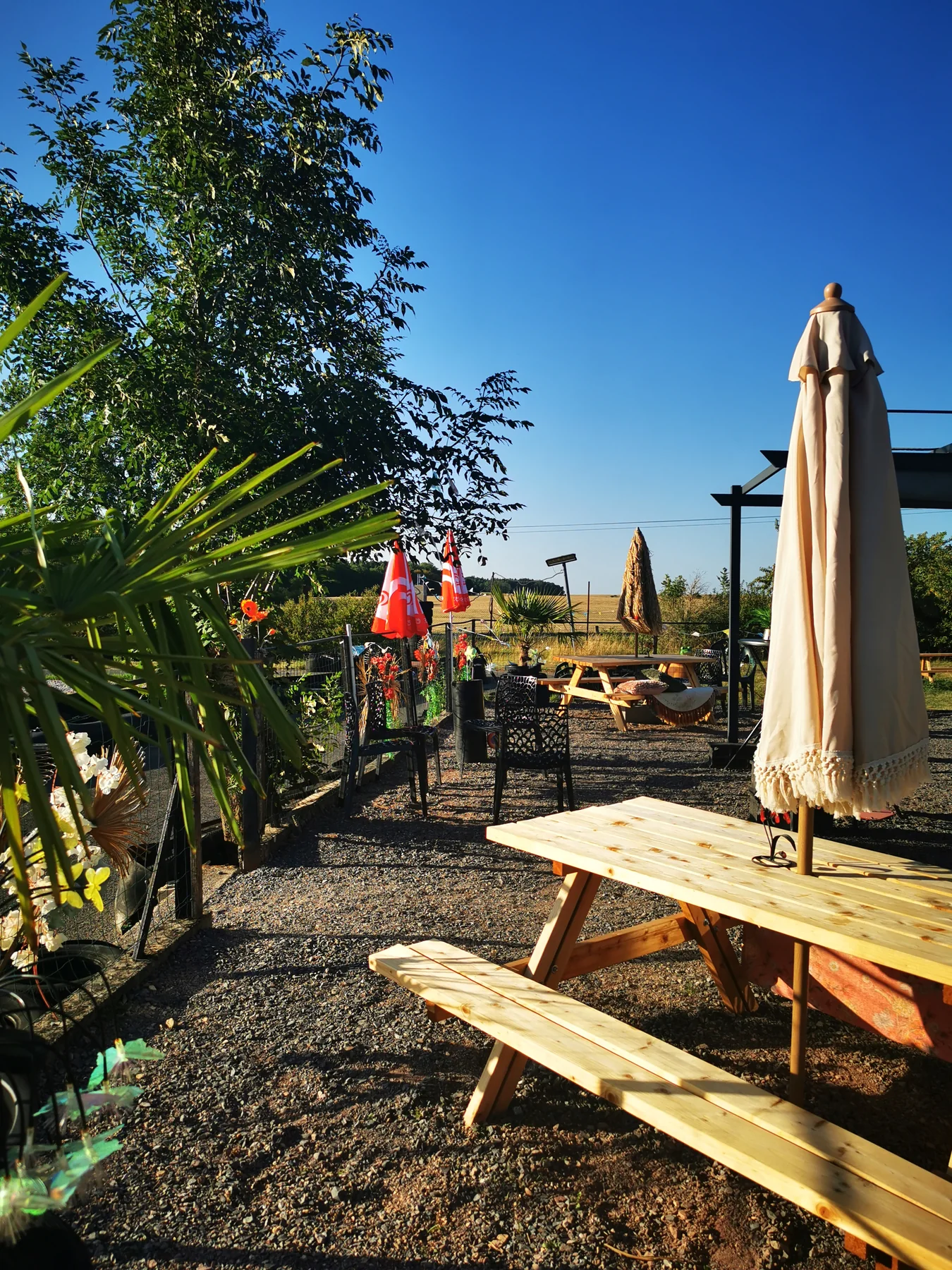 Table de pique-nique et parasol sur la terrasse, face à la piste
